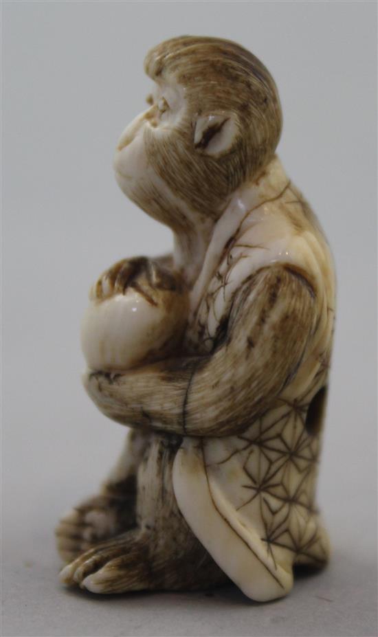 A Japanese ivory netsuke of a seated monkey holding a peach, signed Kogetsu, Meiji period, 3.8cm